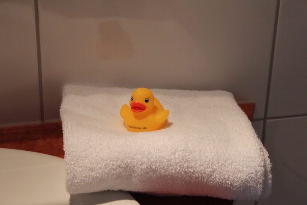 Quietscheente auf Handtuch im Badezimmer
