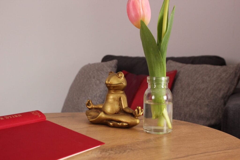 Goldener Frosch, Tulpe in Vase auf Tisch.