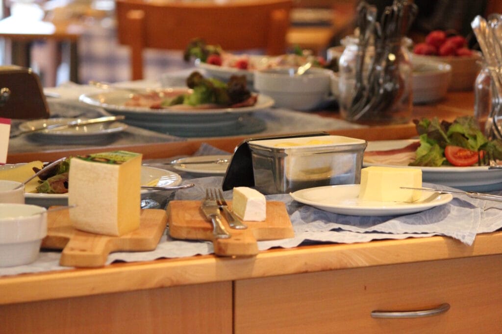 Frühstückstisch mit Käse, Butter und Salat